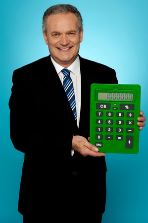 Senior manager showing big green calculator isolated against gradient backgroundの写真素材