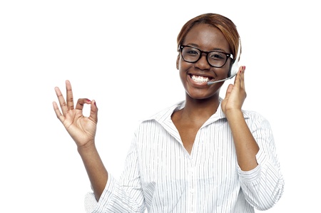 Young customer service agent showing okay gesture to cameraの写真素材