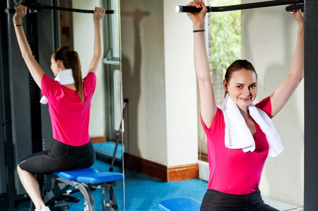 Cute smiling female working out, looking at you