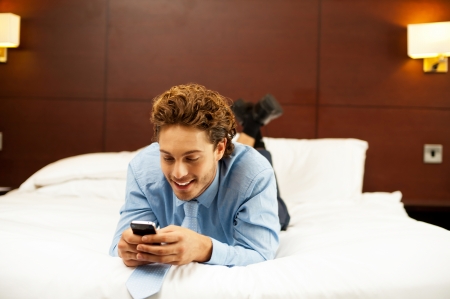 Excited young man waiting for message reply, Messaging with his girlfriend after workの写真素材