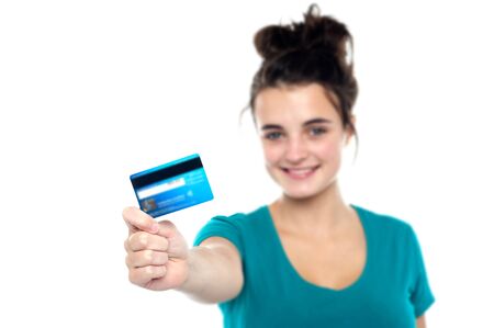 Girl showing her cash card, arm stretched out. Focus on cardの写真素材
