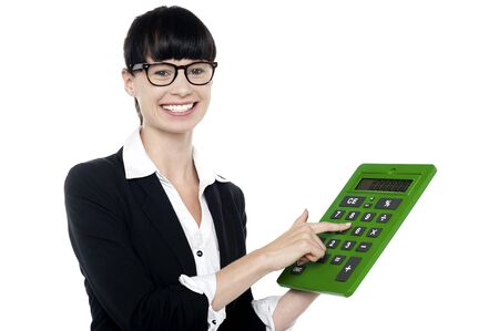 Bespectacled smiling woman using big green calculator, pressing key 5の写真素材