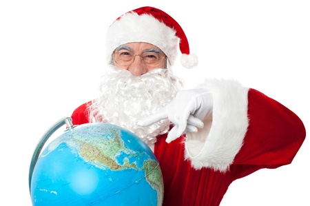 Expressionistic Santa pointing at north pole on globe. All on white backgroundの写真素材