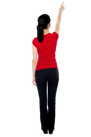 Back pose of woman in casuals pointing away isolated against white. Back pose of woman in casuals pointing away isolated against white.