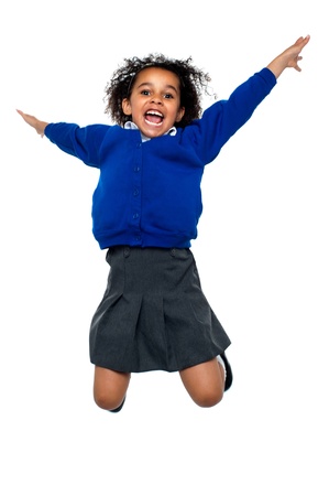 Excited jubilant school kid jumping high up in the air after hearing her annual result.の写真素材