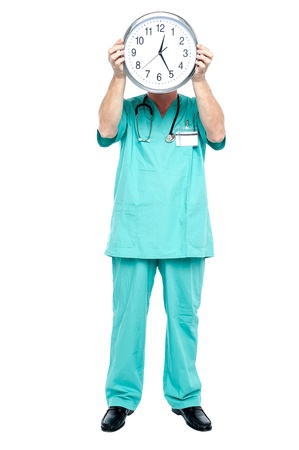 Surgeon holding a clock. Time is critical for the patient's survival.の写真素材
