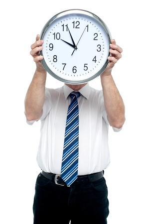 Boss holding a clock in front of his face. Get ready for the meeting in five minutes!の写真素材