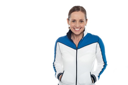 Woman in sporty jacket smiling warmly while facing camera.