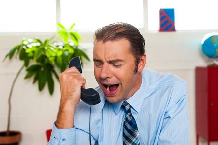 Why are sales so low today? Businessman yelling on phone in his office.の写真素材