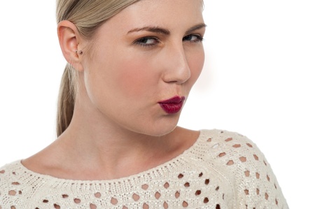 Beautiful teenage blonde with bright red lipstick shade is ready to kiss.の写真素材