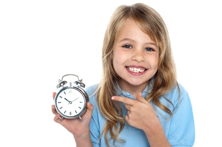 Smiling young girl with an old fashioned clock in hand.の写真素材