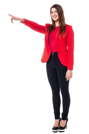 Full length portrait of a young female pointing towards different direction.の写真素材