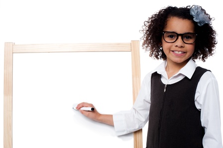 Bright smiling kid writing on whiteboardの写真素材