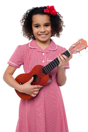 Pretty girl kid loves music. Holding toy guitar in handの写真素材