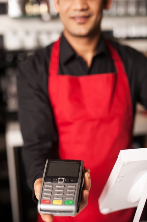 Cropped image of barista staff offering card swipe service to accept paymentの写真素材
