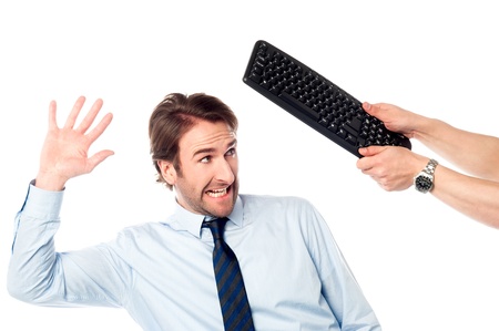Young man trying to avoid getting hit by keyboard