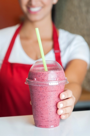 Female chef serving fresh strawberry shakeの写真素材