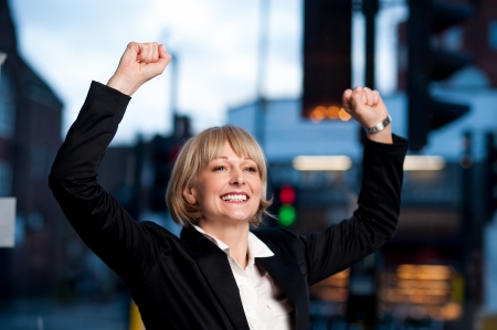 Excited successful businesswoman with arms raised.の写真素材