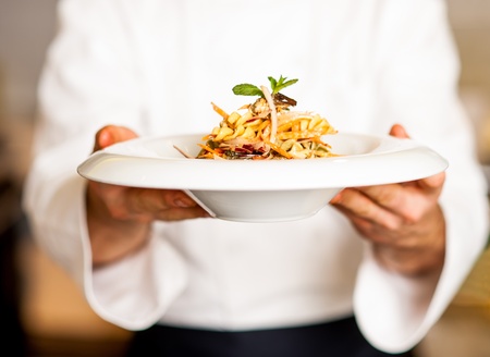 Chef holding mouth watering pasta salad, ready to serve.の写真素材