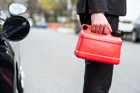 Businessman holding plastic can to refuel it の写真素材