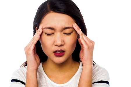 Girl applying gentle pressure on temples of her headの写真素材