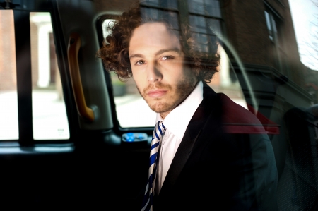 Smart business person travelling in taxi and looking outsideの写真素材