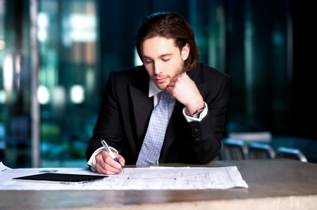 Handsome young businessman busy with his financial year planningの写真素材