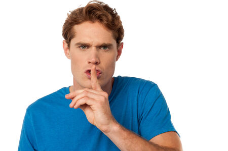 Young casual male shows silence gesture