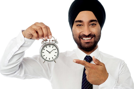 Businessman holding up alarm clock.