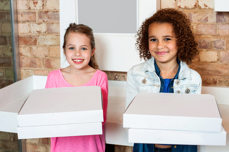Attractive little girls posing with pizza boxwsの写真素材