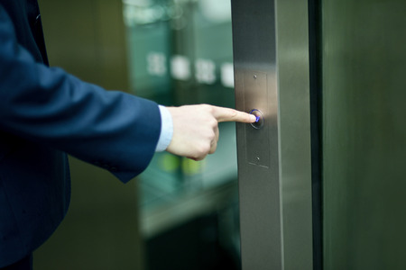 Businessman pressing elevator buttonの写真素材