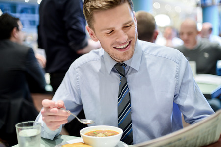 Businessman reading a newspaper in a restaurantの写真素材
