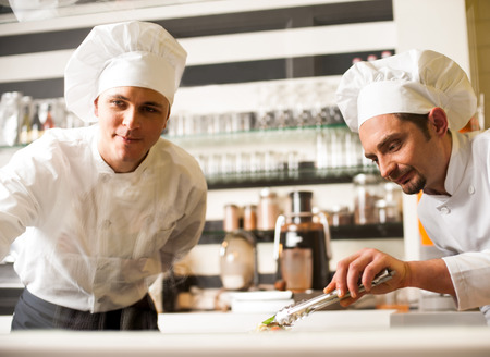 Young chefs preparing delicatessen dishes の写真素材