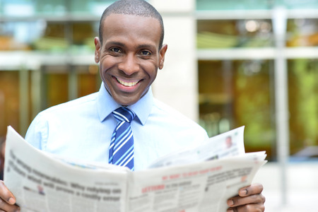 Handsome african businessman reading a newspaper at outdoorsの写真素材