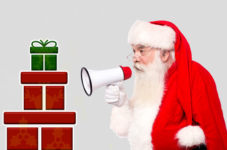 Santa Claus with megaphone and stack of giftsの写真素材