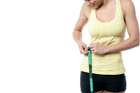 Slender woman measuring her waistの写真素材