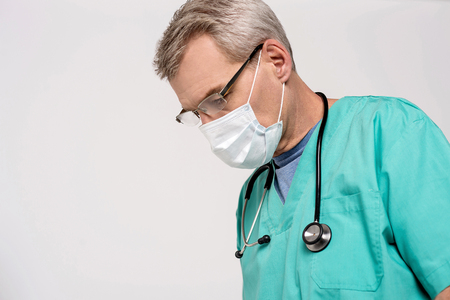 Concentrated male doctor with surgical maskの写真素材