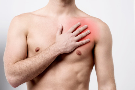 Male suffering pain on his chest muscleの写真素材