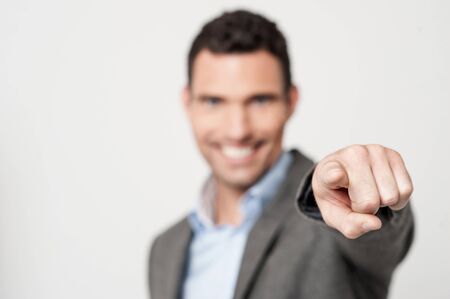 Smiling businessman pointing you out