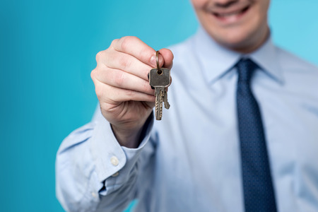 Cropped image of realtor offering a house key