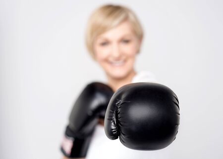 Closeup of woman posing with black boxing glovesの写真素材