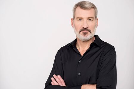 Handsome mature man smiling with arms crossed