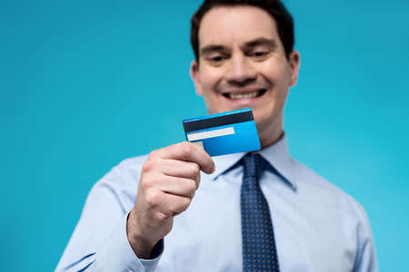 Smiling corporate man looking his new debit cardの写真素材