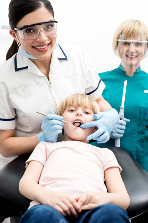 Dentist and assistant examining a little girl patientの写真素材