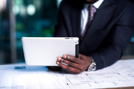 Cropped image of businessman working on tablet PCの写真素材