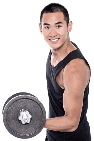 Young man lifting a dumbbell with his left armの写真素材