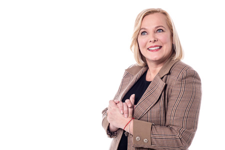 Confident woman looking at camera with clasped hands.の写真素材