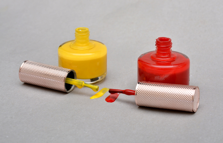 Two Bottles with spilled nail polish over white background.の写真素材