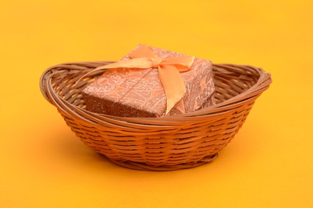 Gift Box inside Wooden basket on yellow backgroundの写真素材