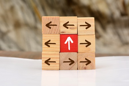 Growing Up concept with wood blocks arrow going upward.の写真素材